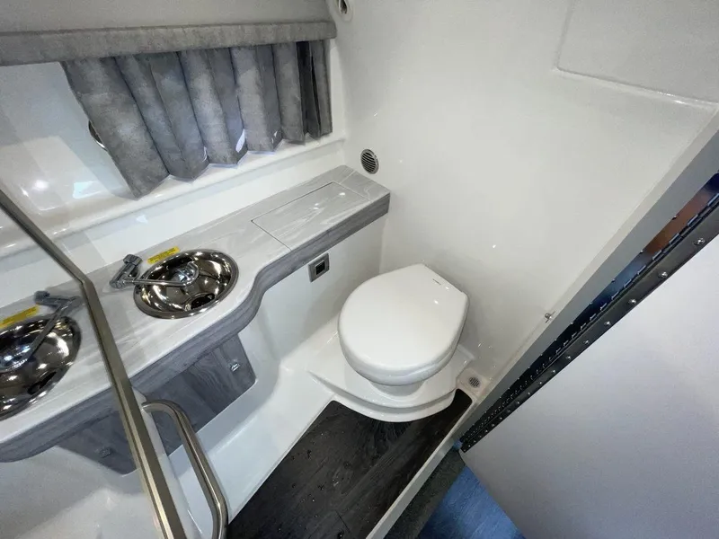 Slide: The Image of 2026 Formula 310 Sun Sport boat bathroom with toilet and sink, featuring modern design. - 16