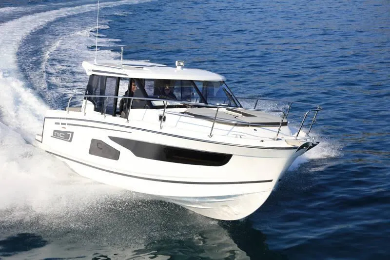 The Image of 2026 Jeanneau NC 1095 Coupe boat on display under a cloudy sky. - 0