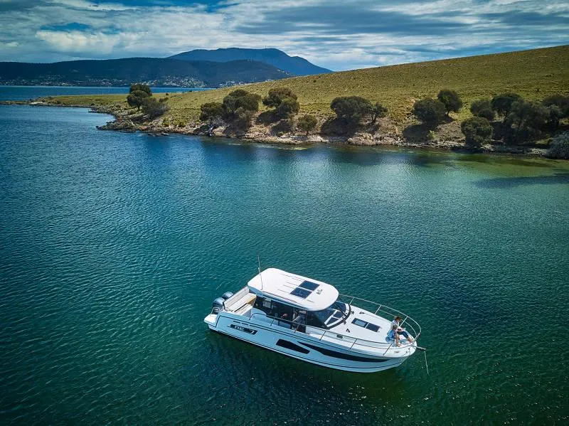 Slide: The Image of 2025 Jeanneau NC 1095 Weekender cruising on open water, showcasing sleek design and performance. - 2