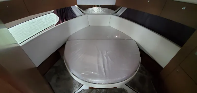 Slide: The Image of 2025 Jeanneau NC 1095 Weekender cabin with round bed, modern design, and yellow accents. - 21