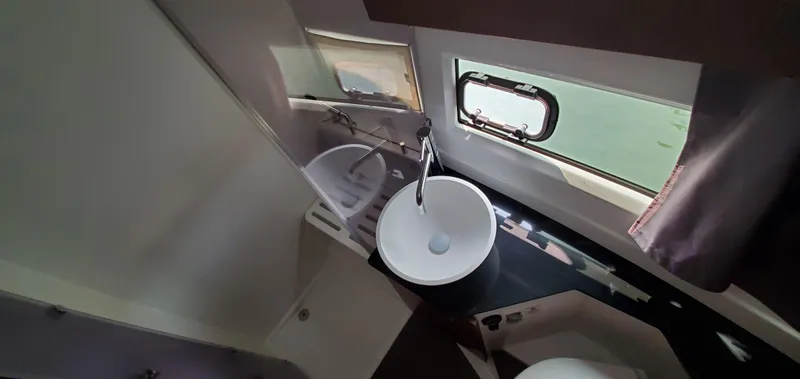 Slide: The Image of 2025 Jeanneau NC 1095 Weekender interior with compact fridge and cozy sleeping area. - 24