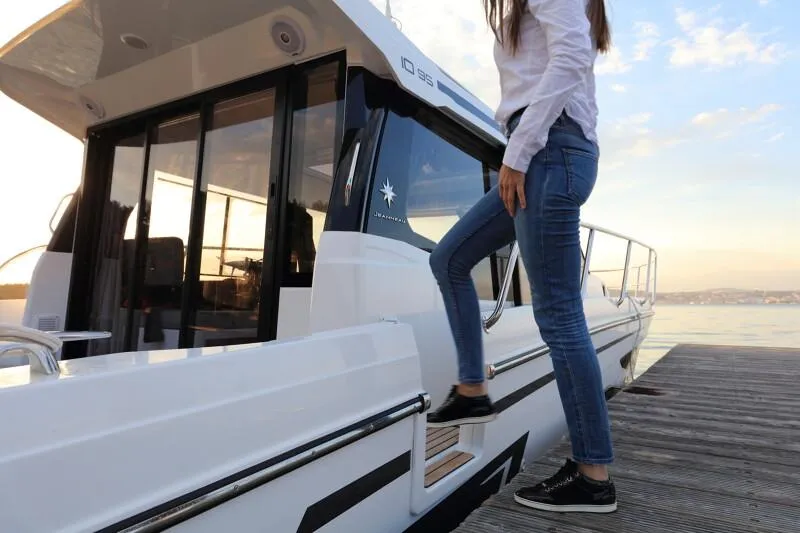 Slide: The Image of 2025 Jeanneau NC 1095 Weekender cruising on serene waters near a scenic coastline. - 4