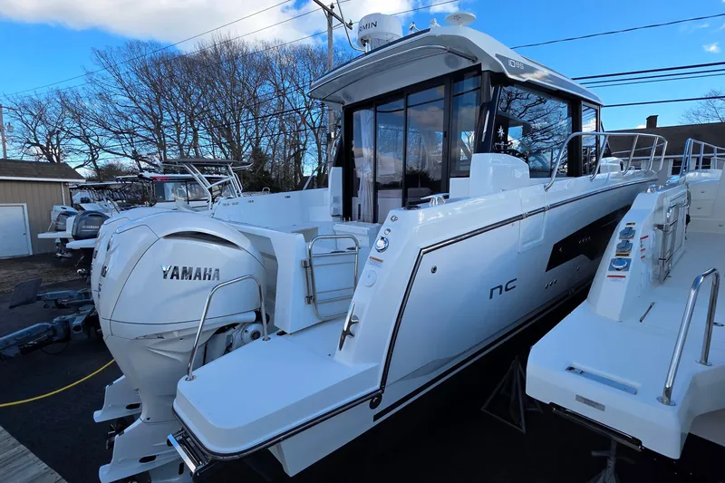 Slide: The Image of 2026 Jeanneau NC 1095 Coupe boat with Yamaha engine, docked outdoors. - 56