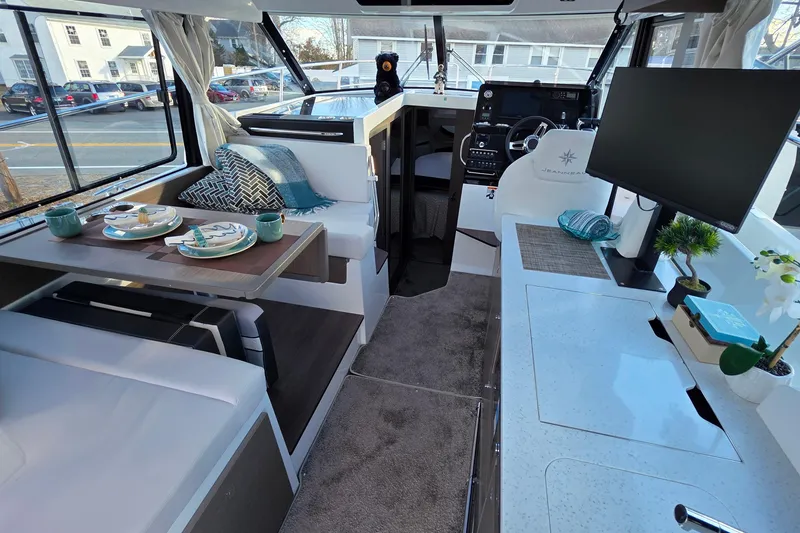 Slide: The Image of Interior of 2026 Jeanneau NC 1095 Coupe, featuring dining area and helm station. - 59