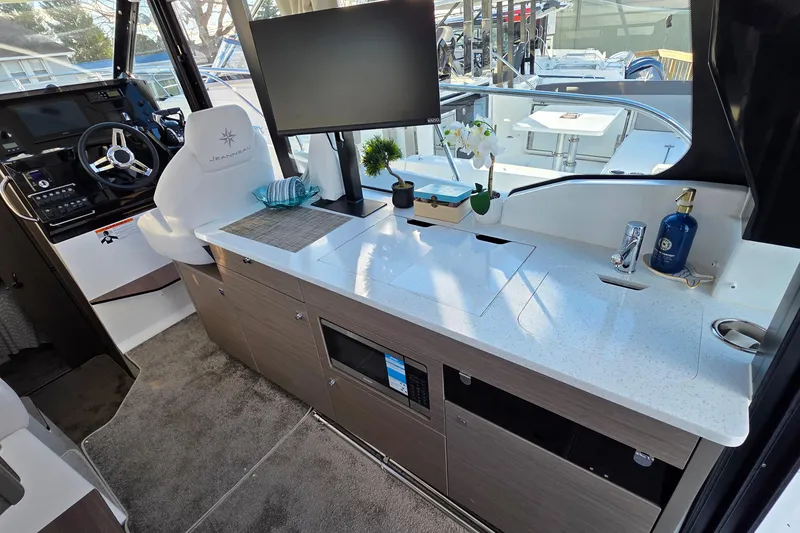 Slide: The Image of Interior of 2026 Jeanneau NC 1095 Coupe with helm, countertop, and modern amenities. - 60