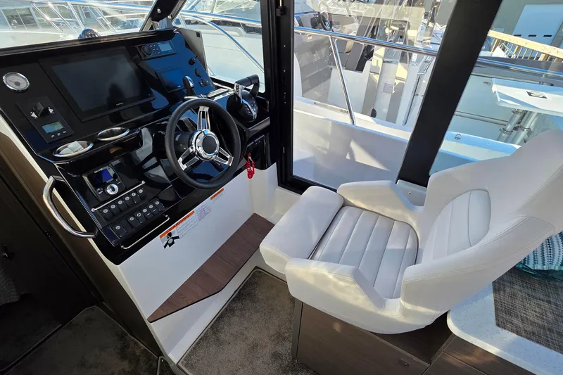 Slide: The Image of Helm station of 2026 Jeanneau NC 1095 Coupe with modern controls and comfortable seating. - 61