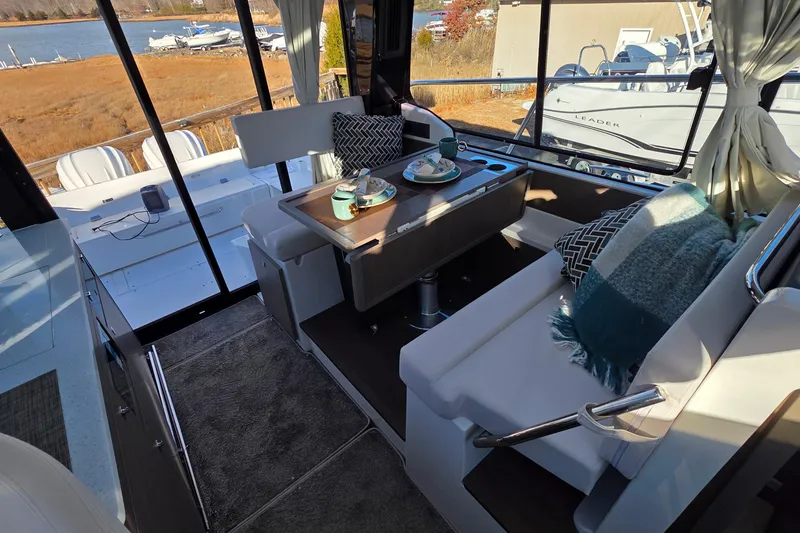 Slide: The Image of Interior of 2026 Jeanneau NC 1095 Coupe with cozy seating and table setup. - 62