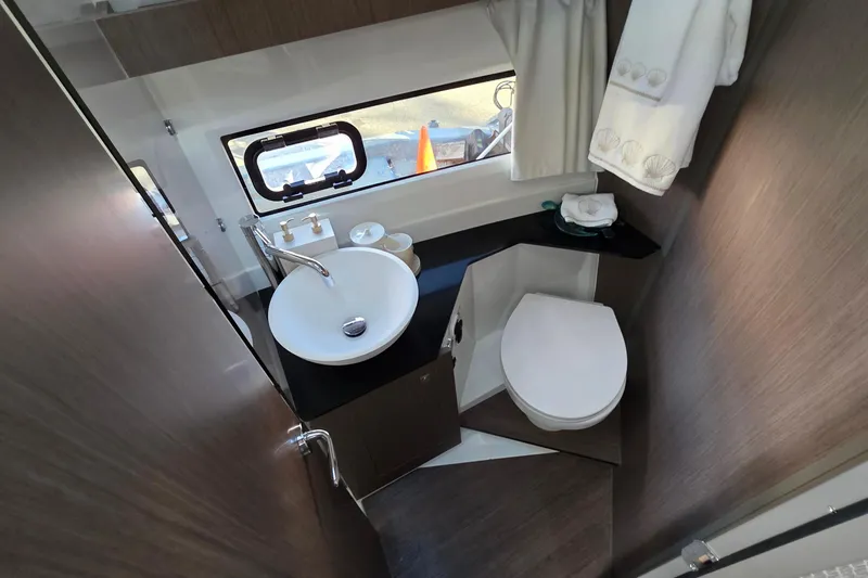 Slide: The Image of 2026 Jeanneau NC 1095 Coupe bathroom with modern sink, toilet, and window. - 63