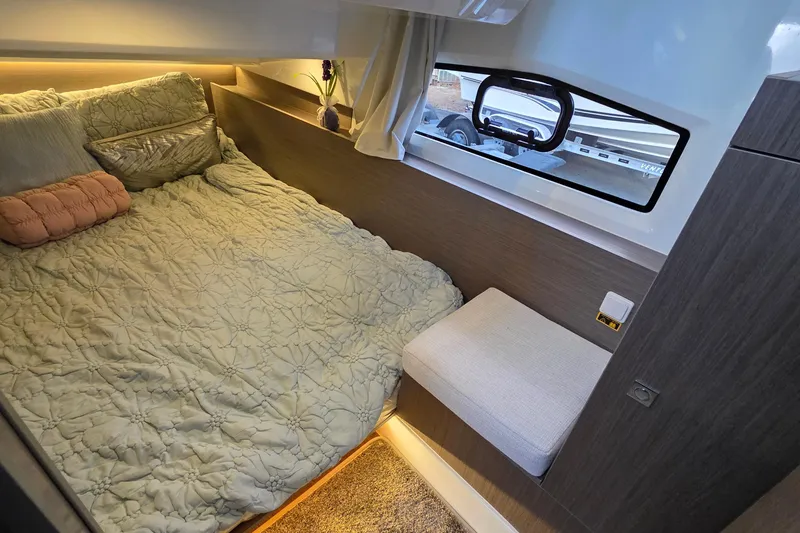Slide: The Image of Cozy cabin interior of 2026 Jeanneau NC 1095 Coupe with bed and window view. - 70