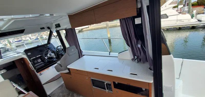 Slide: The Image of Interior of 2025 Jeanneau NC 1095 Weekender with seating and table, docked at marina. - 9