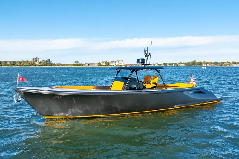 Slide: The Image of 2025 Wajer 38s boat on water, sleek black design with yellow accents. - 1