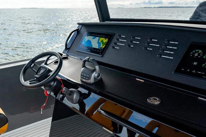 Slide: The Image of Wajer 38s 2025 boat dashboard with navigation screens and steering wheel on open water. - 19