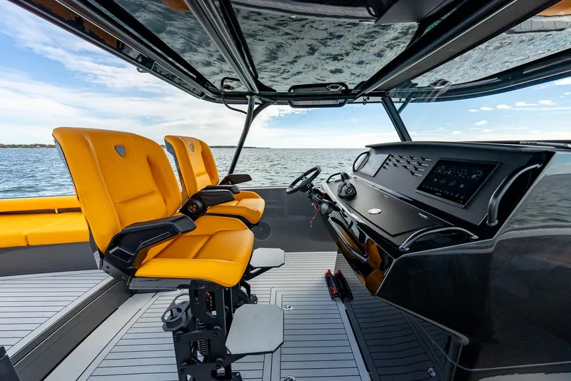 Slide: The Image of 2025 Wajer 38s boat interior with orange seats and modern dashboard on open water. - 2