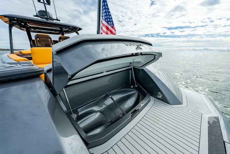 Slide: The Image of 2025 Wajer 38s yacht with open storage compartment, American flag, and ocean backdrop. - 28