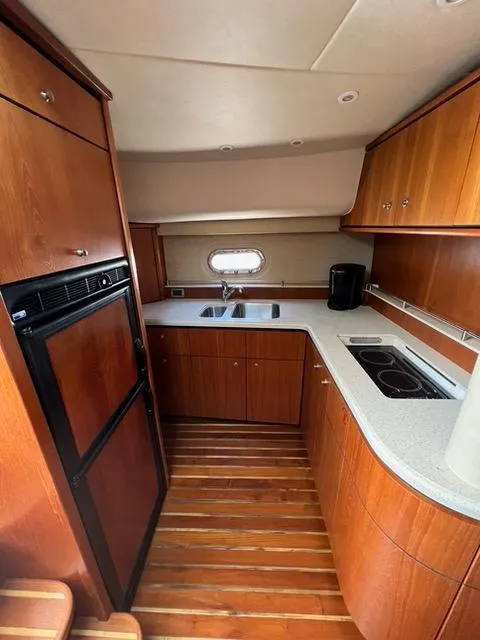Slide: The Image of 2007 Tiara Yachts 4300 Sovran kitchen with wood cabinetry and modern appliances. - 32