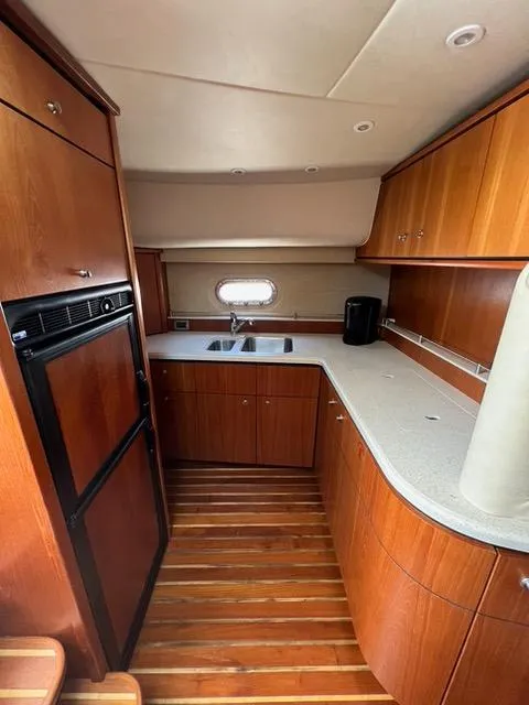 Slide: The Image of 2007 Tiara Yachts 4300 Sovran kitchen with wood cabinetry and modern appliances. - 33