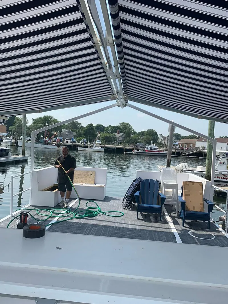 Slide: The Image of Custom 2022 MKI Pontoon Boat with striped canopy, docked at marina. - 8