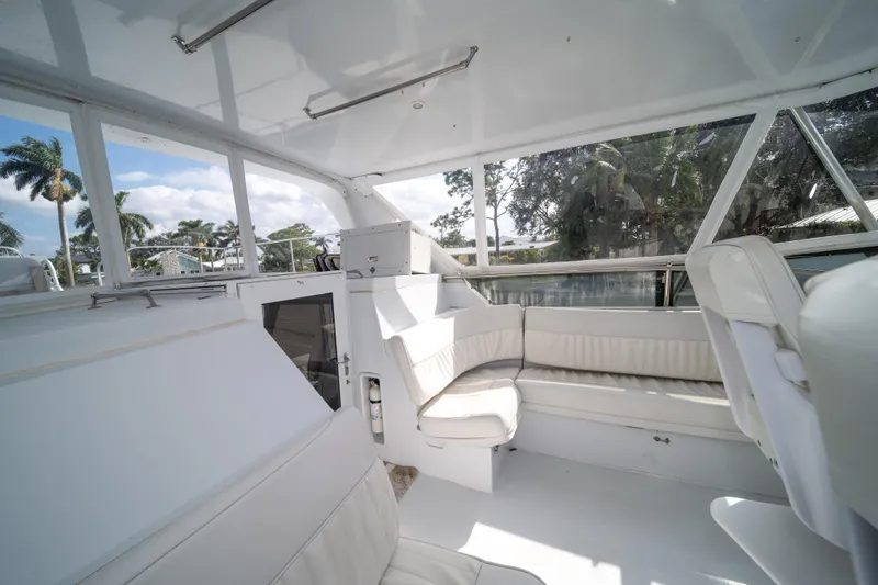 Slide: The Image of Interior of 1999 Hatteras 52 Cockpit Motor Yacht with white seating and large windows. - 18