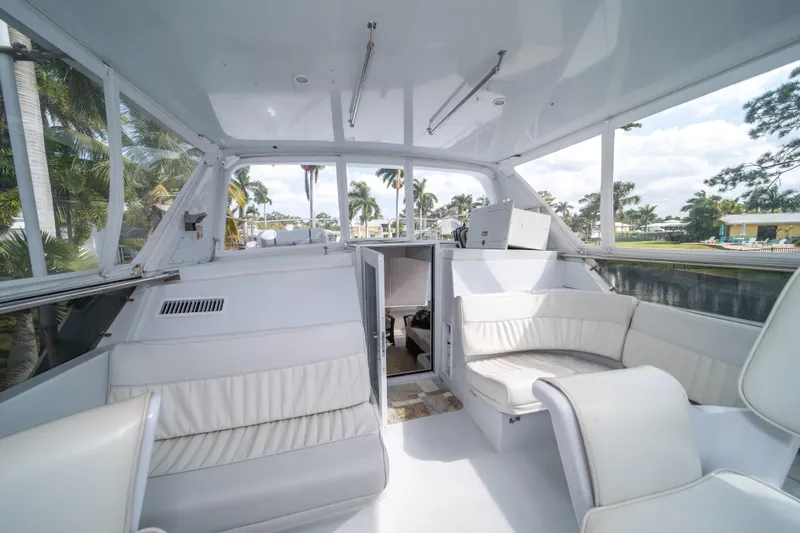 Slide: The Image of Interior of 1999 Hatteras 52 Cockpit Motor Yacht with white seating and panoramic windows. - 19