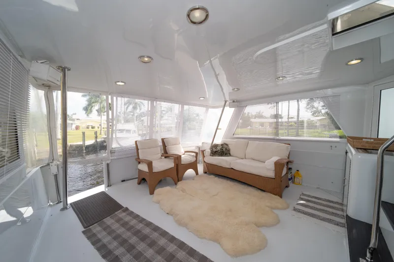 Slide: The Image of Spacious interior of 1999 Hatteras 52 Cockpit Motor Yacht with cozy seating and large windows. - 20