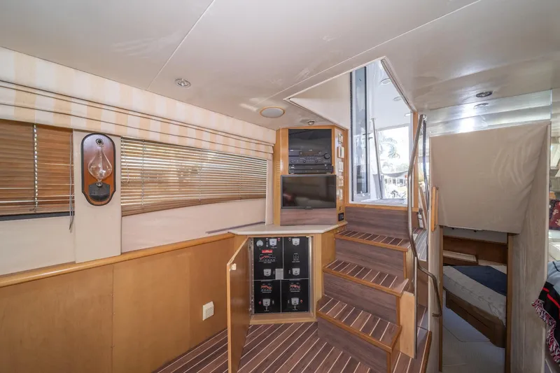 Slide: The Image of Interior of 1999 Hatteras 52 Cockpit Motor Yacht with wooden stairs and modern design. - 24