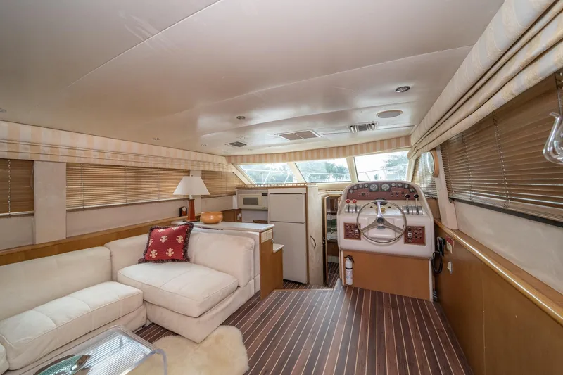 Slide: The Image of Interior of 1999 Hatteras 52 Cockpit Motor Yacht with helm, seating, and wood flooring. - 27