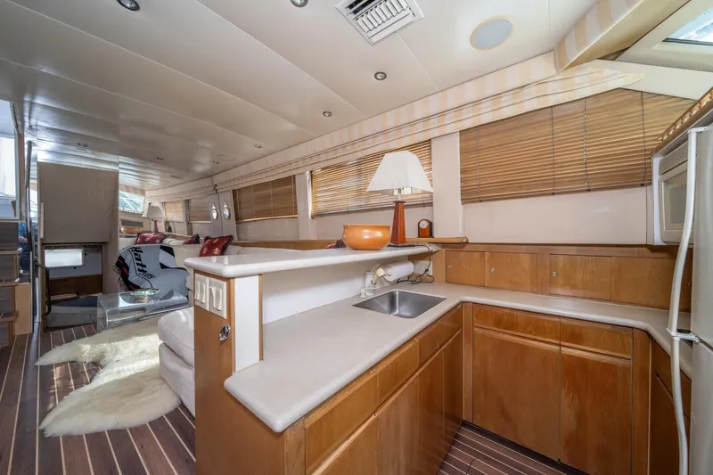 Slide: The Image of Luxurious interior of 1999 Hatteras 52 Cockpit Motor Yacht with modern kitchen and cozy seating. - 29