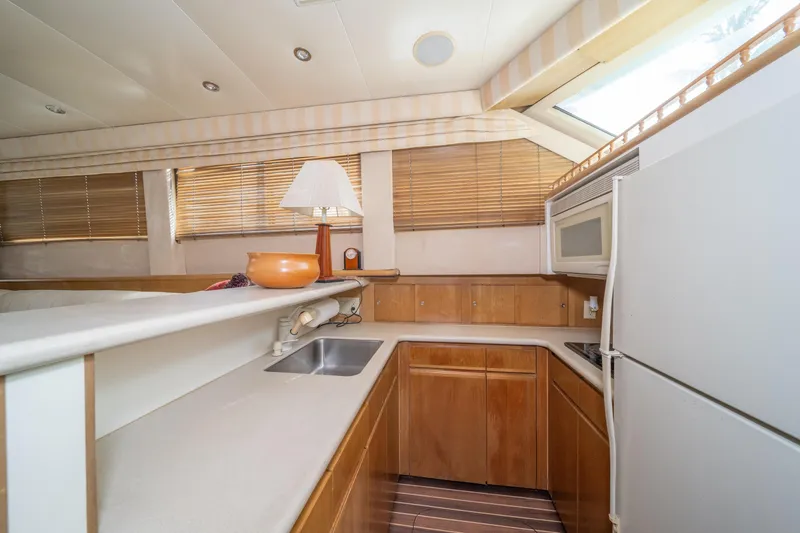 Slide: The Image of Interior of 1999 Hatteras 52 Cockpit Motor Yacht kitchen with wood cabinets and appliances. - 31