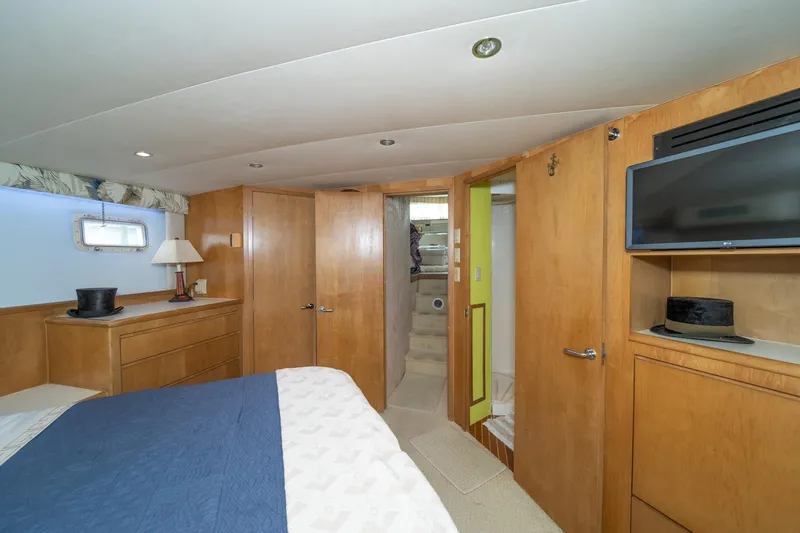 Slide: The Image of Interior of 1999 Hatteras 52 Cockpit Motor Yacht bedroom with wood paneling and modern amenities. - 33