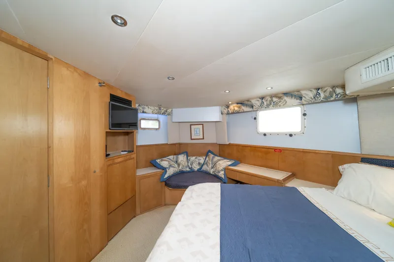 Slide: The Image of Interior of 1999 Hatteras 52 Cockpit Motor Yacht bedroom with cozy bed and seating area. - 35