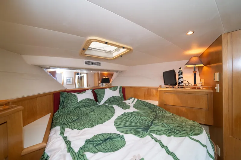 Slide: The Image of Cozy bedroom in 1999 Hatteras 52 Cockpit Motor Yacht with leaf-patterned bedding. - 42