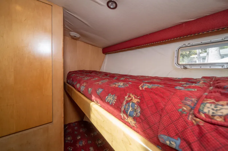 Slide: The Image of Cozy bunk bed with red patterned bedding in 1999 Hatteras 52 Cockpit Motor Yacht. - 47