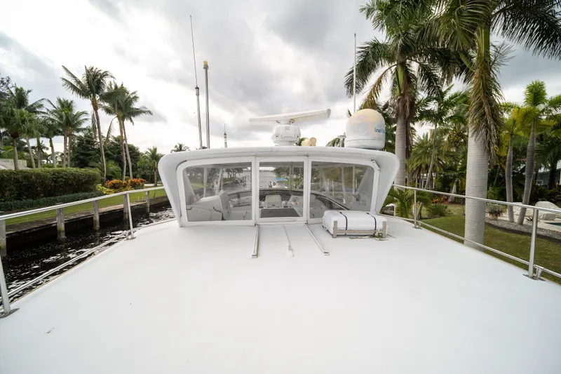 Slide: The Image of 1999 Hatteras 52 Cockpit Motor Yacht docked near palm trees. - 9