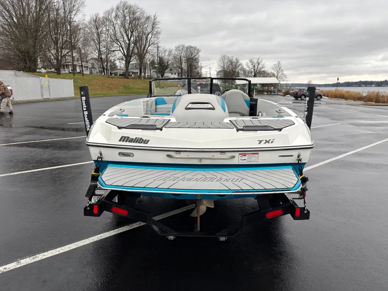 Slide: The Image of 2017 Malibu Response TXi Open Bow boat on trailer in parking lot. - 8