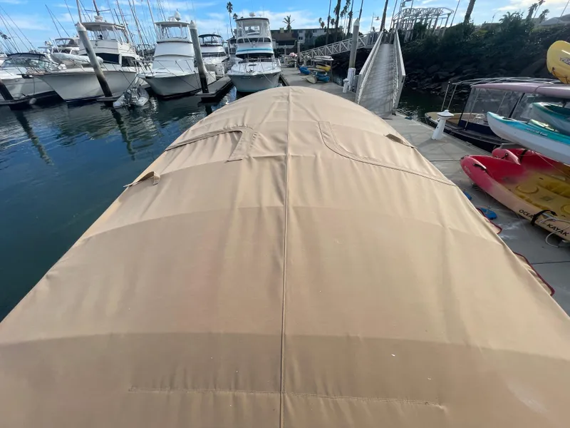 Slide: The Image of 2018 Duffy Bay Island 22 boat with tan cover docked at marina. - 12