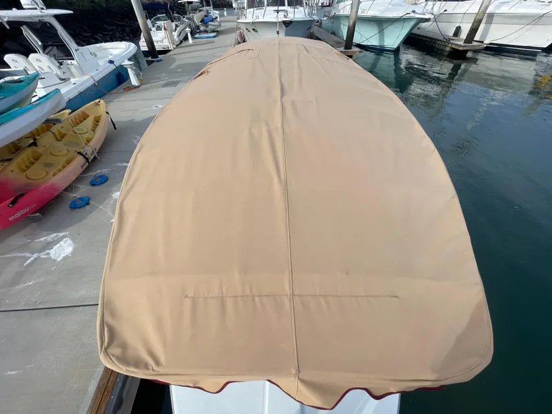 Slide: The Image of 2018 Duffy Bay Island 22 boat with tan cover docked at marina. - 13