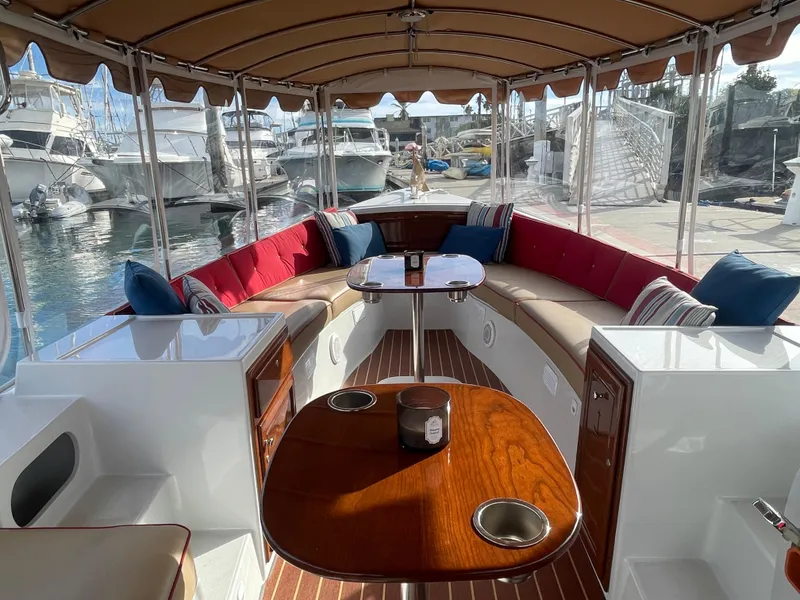 Slide: The Image of 2018 Duffy Bay Island 22 boat interior with seating, table, and canopy at marina. - 15