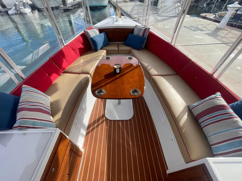 Slide: The Image of 2018 Duffy Bay Island 22 boat interior with red and beige seating, striped cushions, and wooden table. - 6