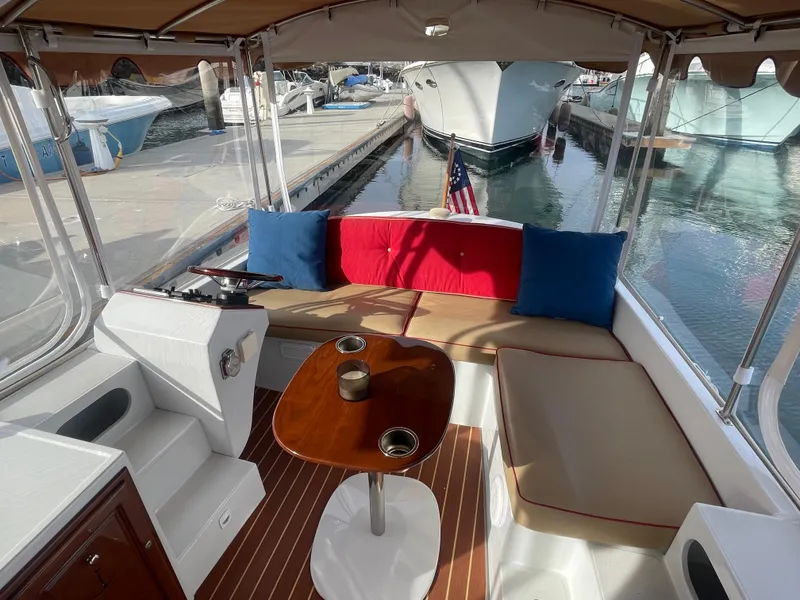 Slide: The Image of 2018 Duffy Bay Island 22 boat interior with seating, table, and docked at marina. - 9