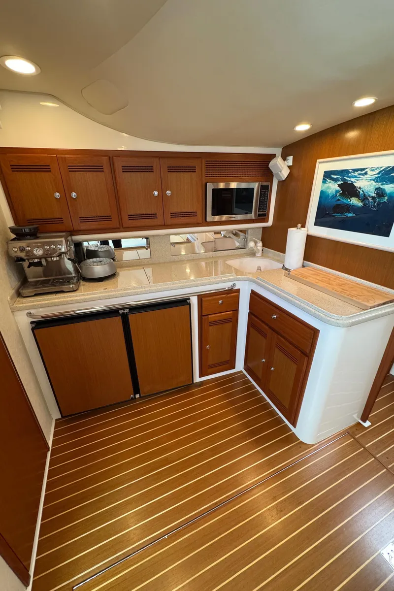 Slide: The Image of 2005 Cabo 40 Express yacht kitchen with wooden cabinets and modern appliances. - 14