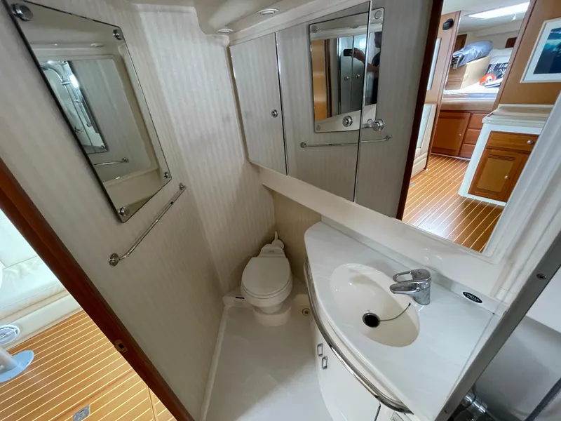 Slide: The Image of Bathroom interior of 2005 Cabo 40 Express yacht, featuring sink, toilet, and mirrors. - 18