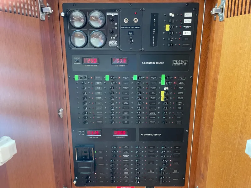Slide: The Image of Electrical control panel on a 2005 Cabo 40 Express boat, featuring gauges and switches. - 20