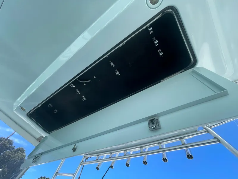 Slide: The Image of Cabo 40 Express 2005 boat storage compartment with rod holders, open against clear blue sky. - 22