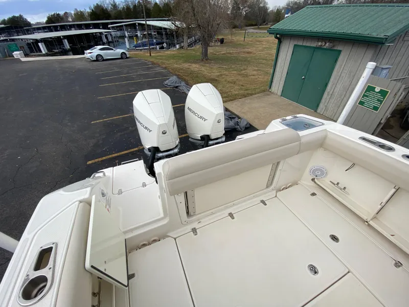 Slide: The Image of 2020 Boston Whaler 280 Outrage with dual Mercury engines, parked near a green shed. - 16