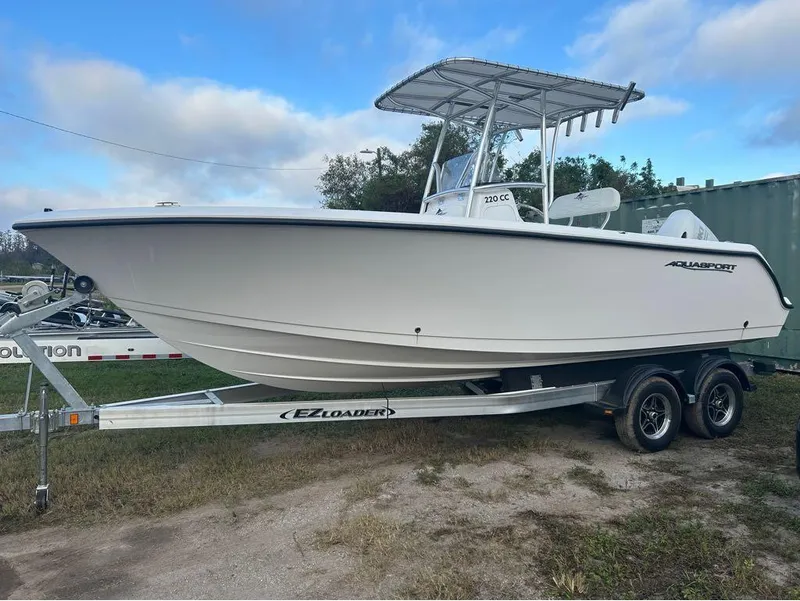 Slide: The Image of 2024 Aquasport 2200 CC boat on trailer, side view, outdoors. - 1