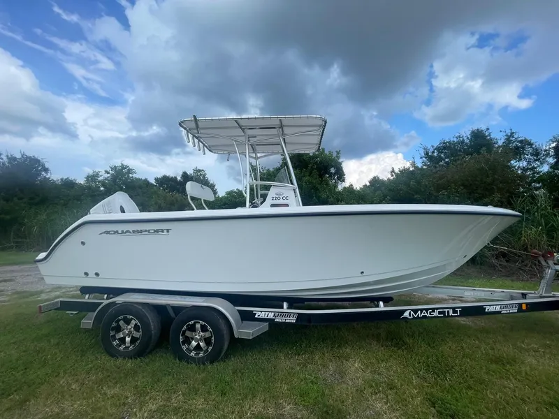 Slide: The Image of 2024 Aquasport 220 CC boat on trailer under cloudy sky. - 10