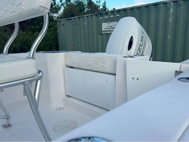 Slide: The Image of 2024 Aquasport 2200 CC boat interior with Suzuki engine, white seating, and metal frame. - 12