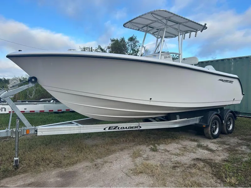 Slide: The Image of 2024 Aquasport 2200 CC boat on EZ Loader trailer, parked outdoors. - 14