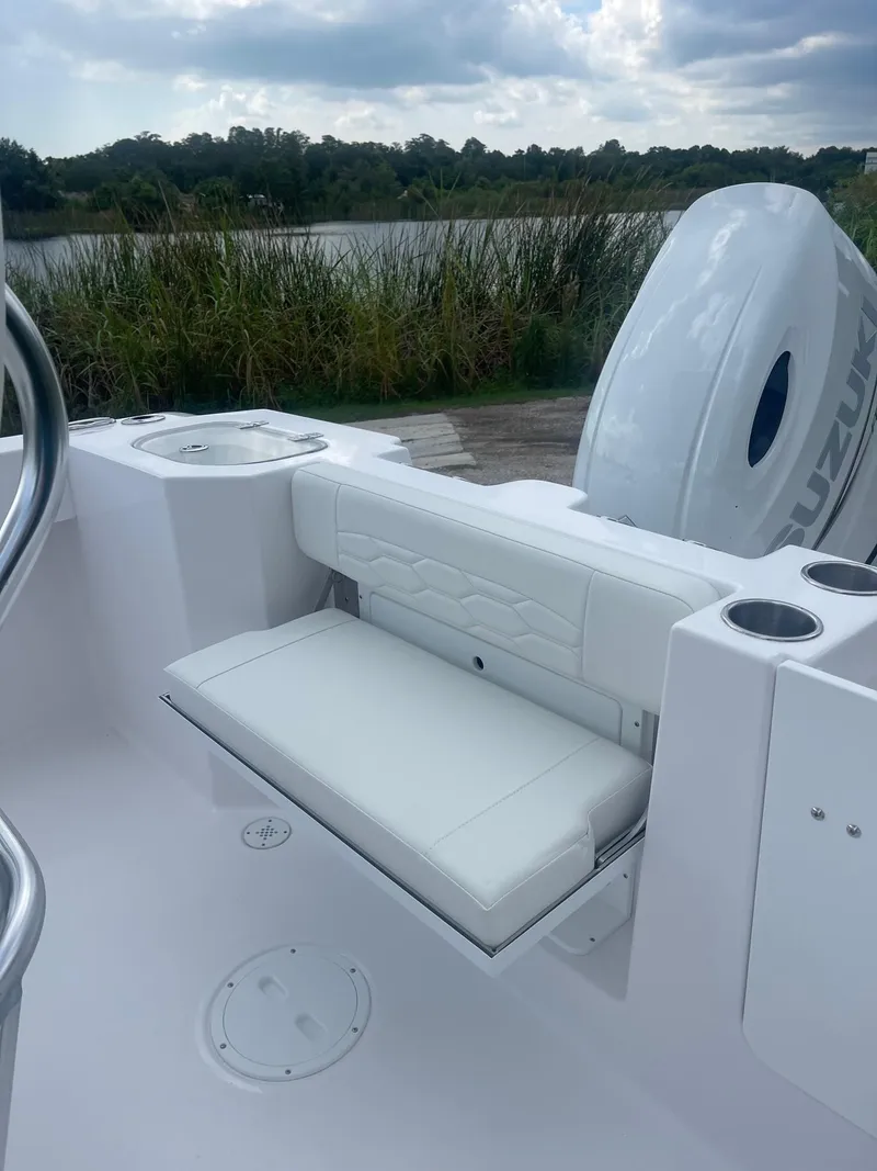 Slide: The Image of 2024 Aquasport 220 CC boat interior with white seating and Suzuki engine. - 15