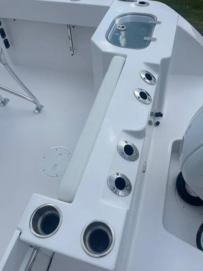 Slide: The Image of 2024 Aquasport 220 CC boat interior with rod holders and storage compartments. - 2